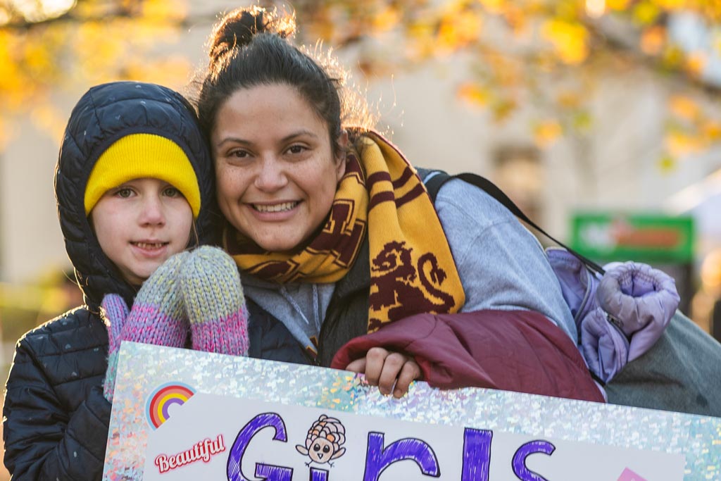 Mom and daughter holding a sign at the Arlington Turkey Trot